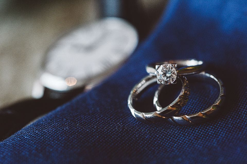 An engagement ring and a wedding band resting on dark blue velvet