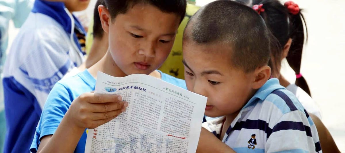 Two boys reading a reply letter together