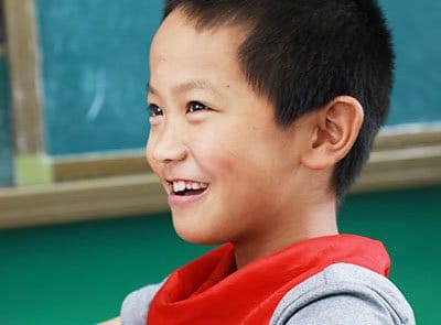 A boy laughing in his school uniform