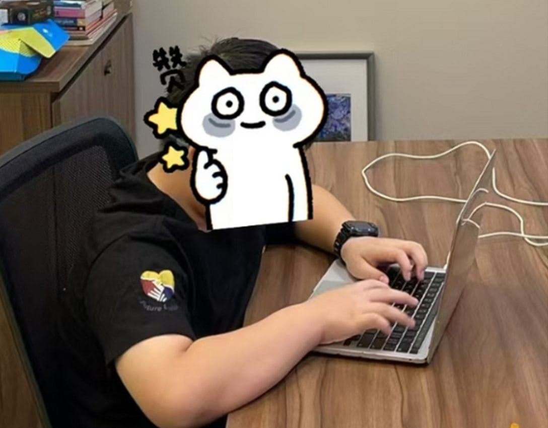 A student in a Future Envision polo shirt typing at a laptop in the study room