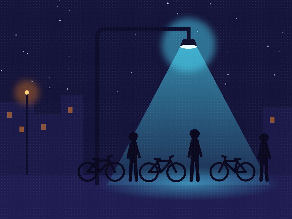 Riders with their bikes under a street lamp