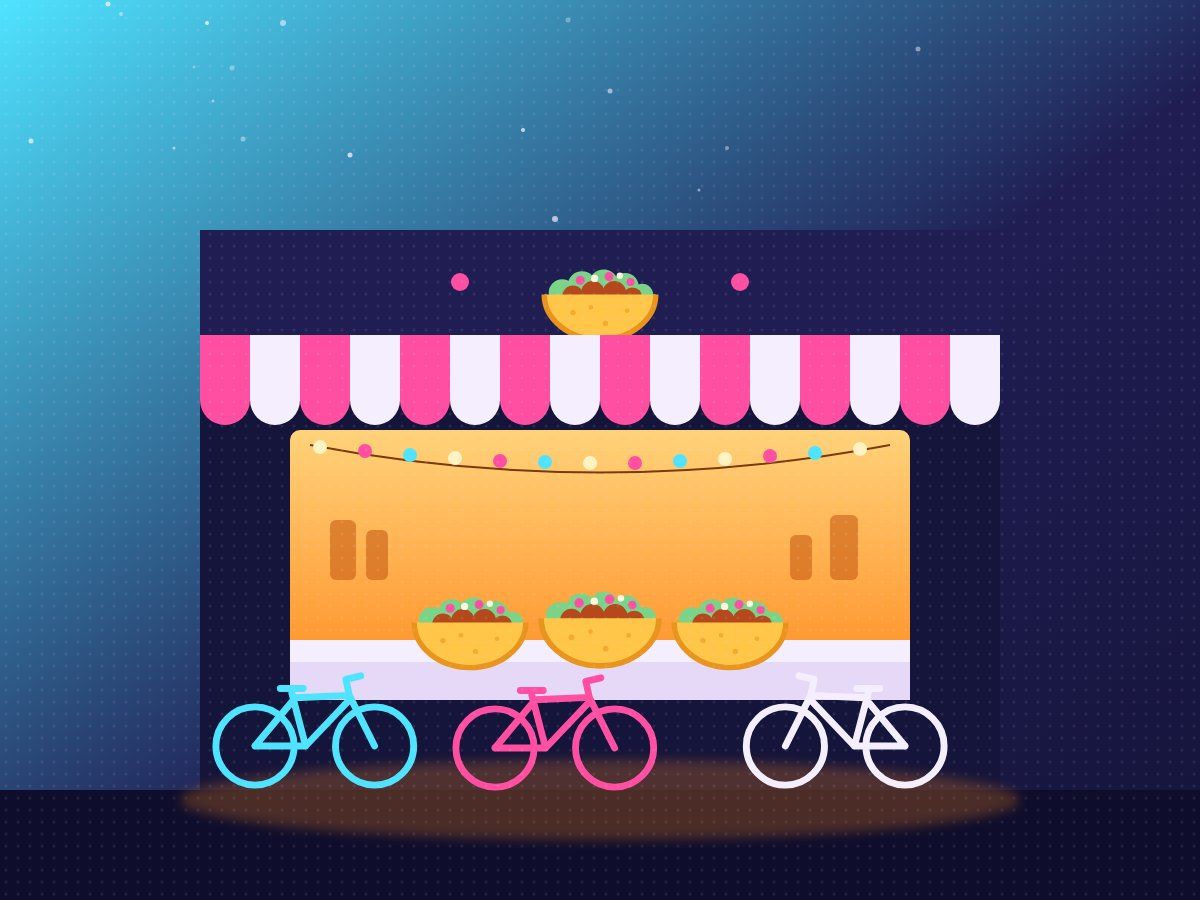 Bikes parked outside a glowing taco stand at night