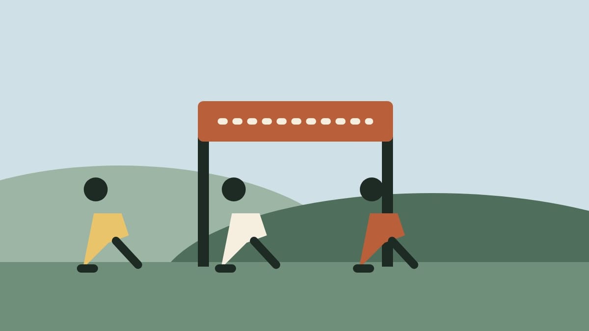 Runners crossing a finish arch on a green hill