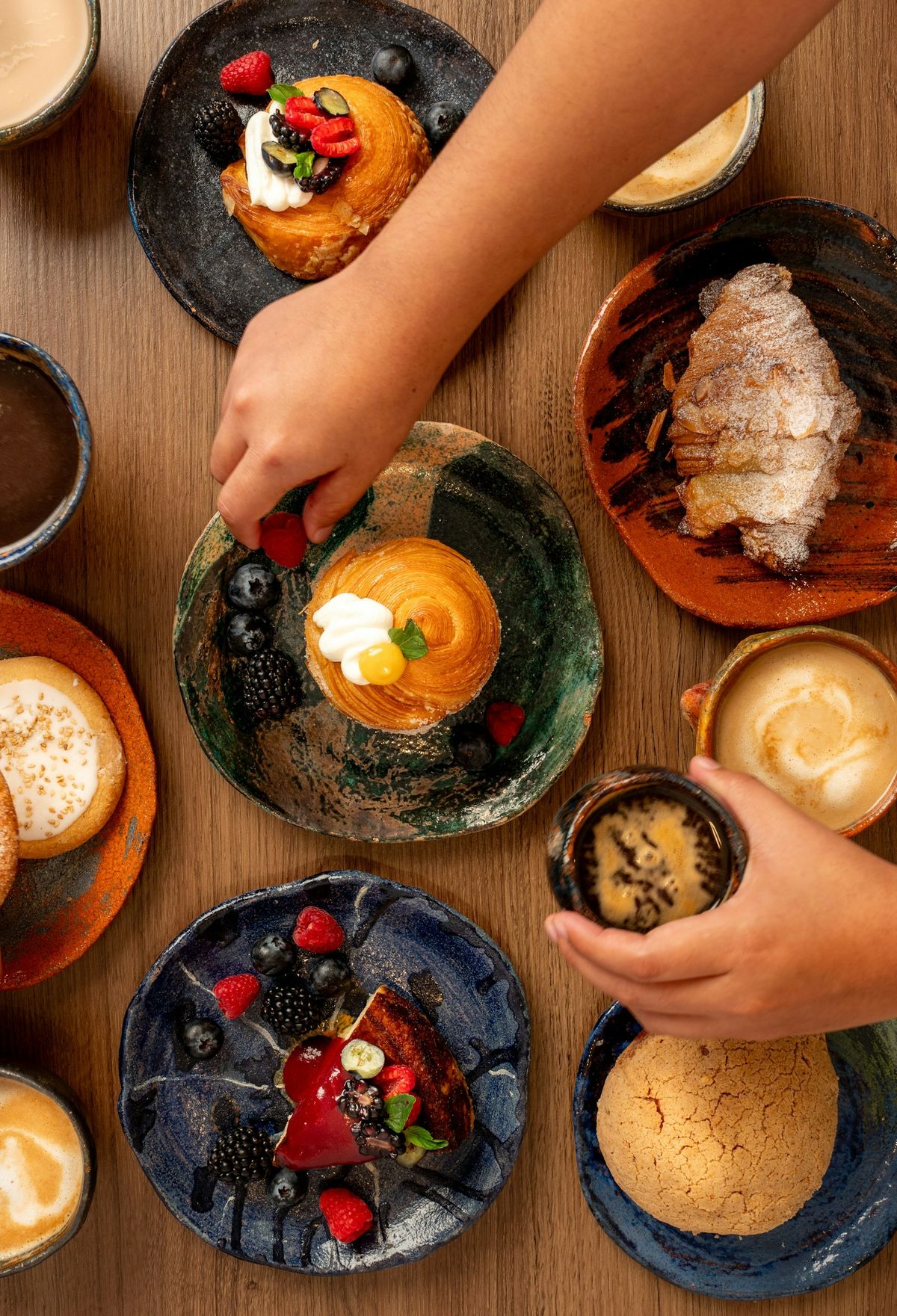 A table of colorful desserts with a hand reaching in