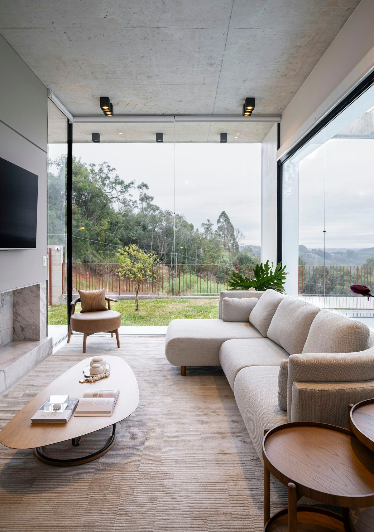 A sofa and low table in a living room with a view of trees