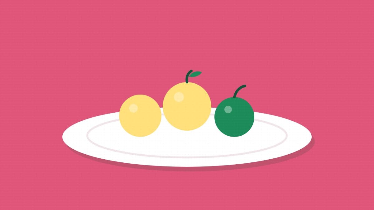 A white plate with yellow and green vegetables on a pink background